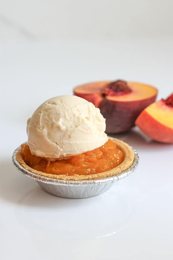 Mini Peach Pies close up with peaches in the background